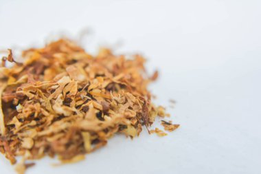 Beyaz arka planda kurutulmuş tütün yaprakları.