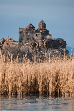 Doğadaki güzel kilise. Kış mevsimi, arka planda bir ağaçla gölde geçen kış