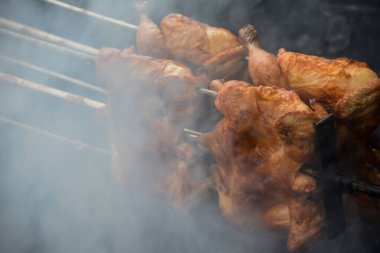 Izgarada ateşte tavuk pişirmek.