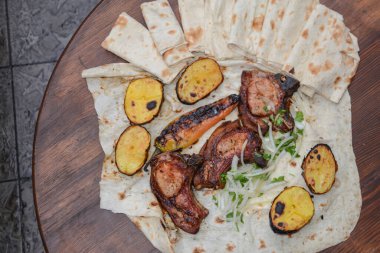 Masada ızgara et ve sebze var.