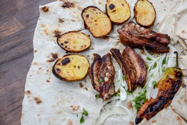 Kızarmış domuz eti, soğan ve patates tabakta, üst manzara, yakın plan.