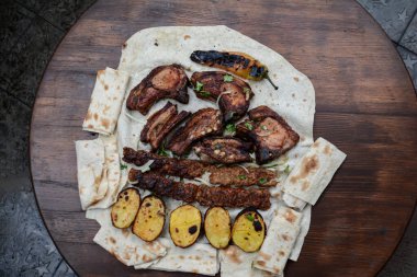 Geleneksel Arap mutfağı, sebzeli ızgara kebap, et ve pita ekmeği, ekmek, ızgara sebze ve baharat. üstte