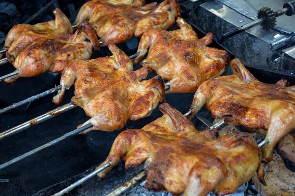 Kızarmış et ateşte. Ateşin üstünde tavuk. Tavuk barbeküsü. Bir restoranda fırında kızarmış tavuk, fotoğrafa yakın çekim. Dumanın içinde ızgara tavuk. Fast food