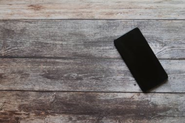 cep telefonu ahşap masada.