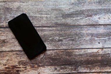 Ahşap arkaplanda boş bir cep telefonu