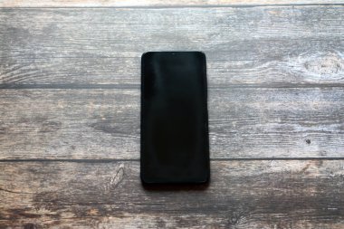 cep telefonu siyah deri çantada.