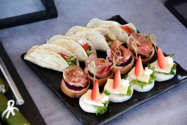 Taze bitkilerle süslenmiş parti için büfe yemeği. Peynirli ve jambonlu sandviç. Lüks restoranda et ve sebzelerle birlikte açık büfe yemekleri. Lezzetli açık büfe masası.