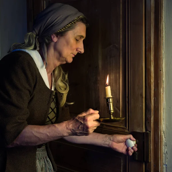 穿着中世纪服装拿着燃烧的蜡烛的女人 — 图库照片