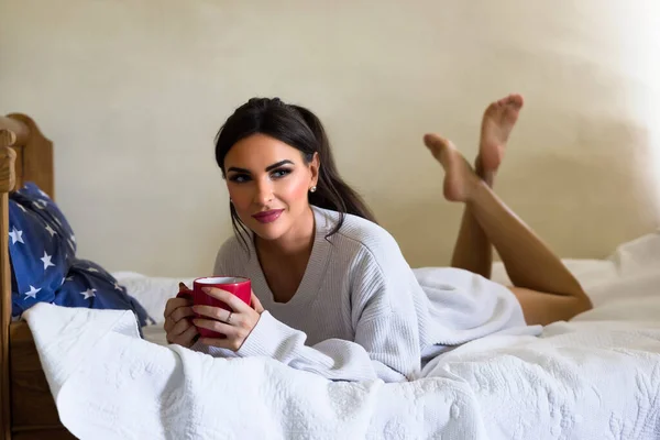 Attractive Young Woman Enjoying Mug Coffee Bed Wearing White Sweater — 스톡 사진