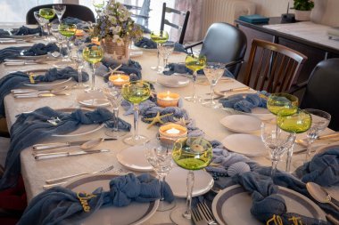 Deniz kabukları ve deniz yıldızlarıyla süslenmiş bir plaj temasını takiben mavi ve altın rengi Noel yemeği masası süslemeleri