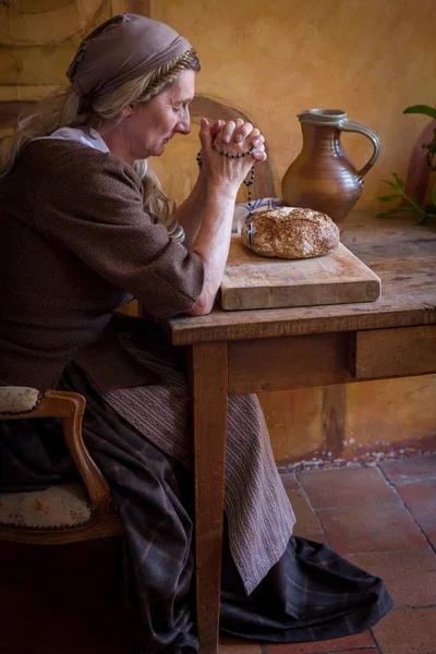 Hakiki Köylü Rönesans Kostümü Giymiş Bir Kadın Masada Dua Ediyor — Stok fotoğraf