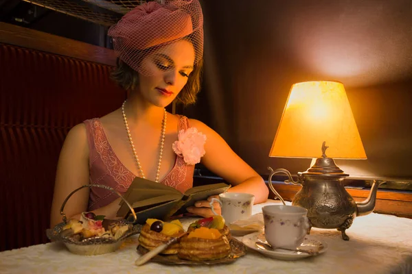 20世纪20年代 在真实的1927年蒸汽机车车厢里 一位穿着华丽连衣裙的女士在品茶 重拍场景 — 图库照片