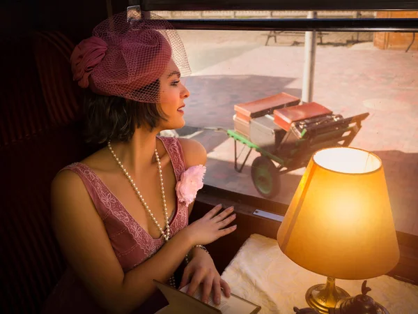20世纪20年代 在真实的1927年蒸汽机车车厢里 一位穿着华丽连衣裙的女士在品茶 重拍场景 — 图库照片