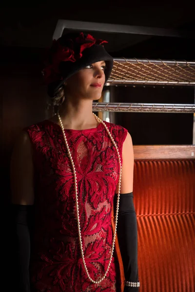 迷人的20世纪20年代女人 穿着红色法兰绒连衣裙 头戴丁字帽 在1927年的一列正宗蒸汽火车的头等舱内摆姿势 — 图库照片