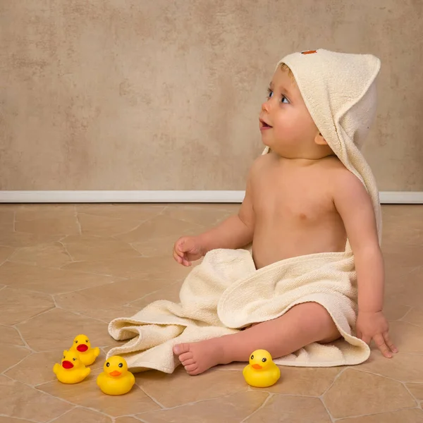 12个月大的小男孩 穿着黄色浴巾 玩肥皂泡和橡皮鸭 — 图库照片