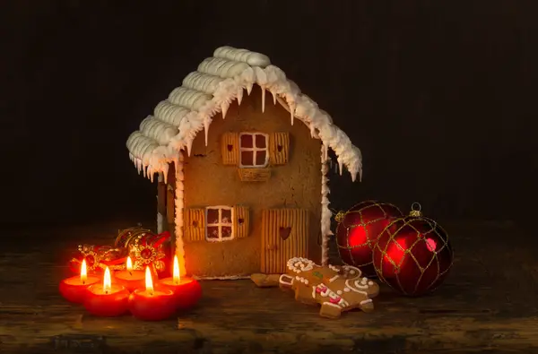 Gingerbread house on rustic wood against a dark background