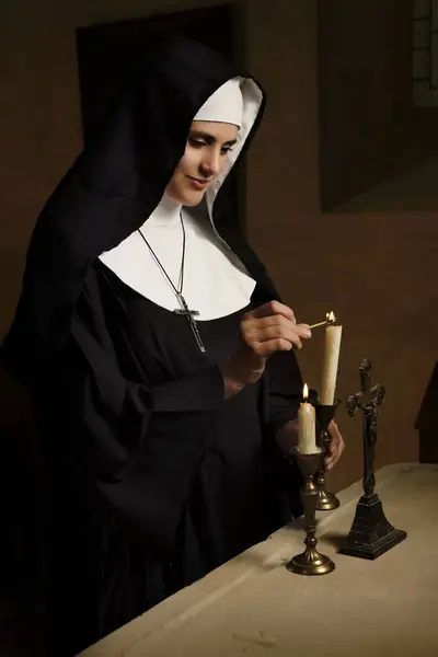 中世のチャペルでカトリック修道女の本物の習慣とベールを身に着けた若い成人女性 ロイヤリティフリーのストック画像