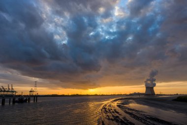 Colorful sunset over Antwerp world port in Belgium, with a view on the towers of the nuclear plant