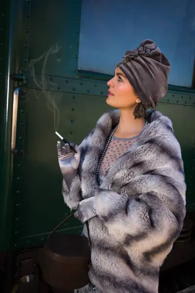 在一个真实的1927年第一流火车车厢旁边的月台上 一个20世纪20年代的美女在那里等着她的行李 图库图片