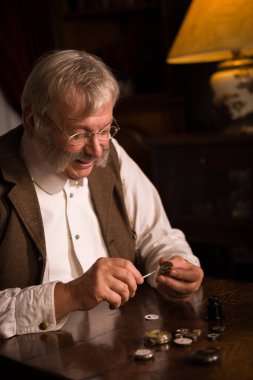 Antika bir cep saati üzerinde çalışan Viktorya döneminden kalma bir saatçinin yakın plan görüntüsü.