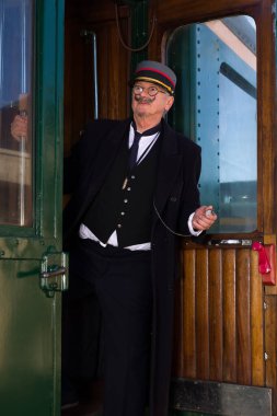 Birinci sınıf tren vagonundan ayrılan eski bir tren kondüktörünün canlandırma sahnesi