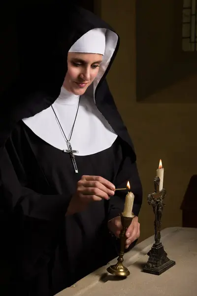 中世のチャペルでカトリック修道女の本物の習慣とベールを身に着けた若い成人女性 ストック写真