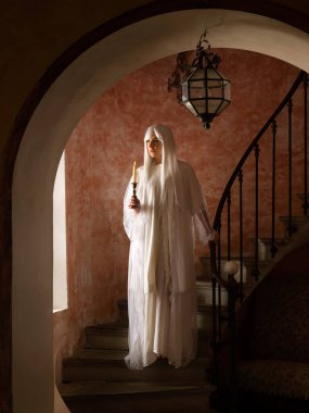 Antika beyaz gecelik giyen kadın hayalet antika bir evde geziniyor.