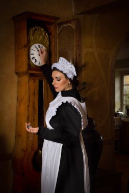 Scenes of a beautiful young Victorian maid doing house chores in an antique interior clipart