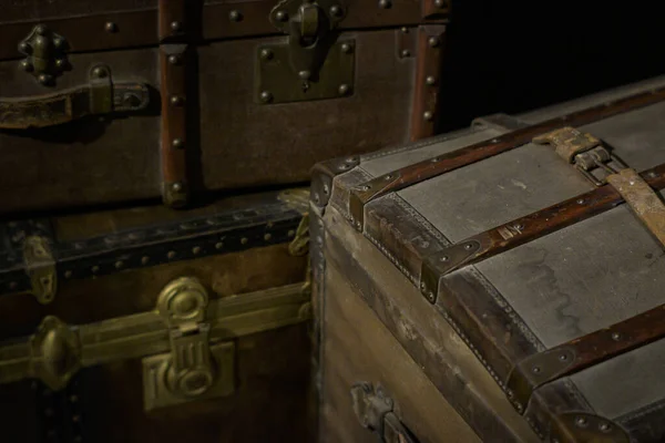 Closeup shot of vintage travel boxes and suitcases with dark background and selective focus.