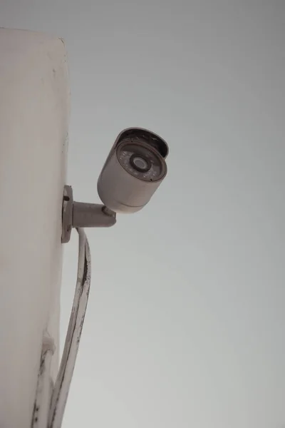 stock image Vertical shot of a domestic security camera mounted against a wall protecting against burglary