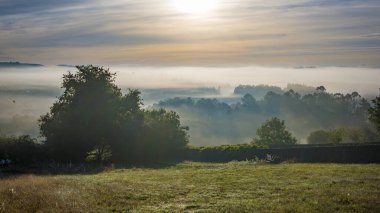 Sabahın erken saatlerinde İspanya 'nın Galiçya kırsal kesiminde sis ve sisle birlikte güneş doğar..