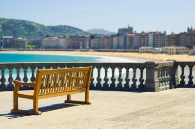 San Sebastian, Bask bölgesi, İspanya 'daki La Concha sahilinde ahşap bank.