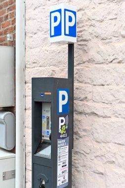 Rochefort, Belgium, December 24th 2024: View on 4411 parking meter pole, a system widely used in Belgium to pay for parking space in cities clipart