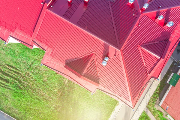 the roof of a building made of iron polymer sheets with ventilation diffusers and air ducts, photographed from a drone at a low altitude