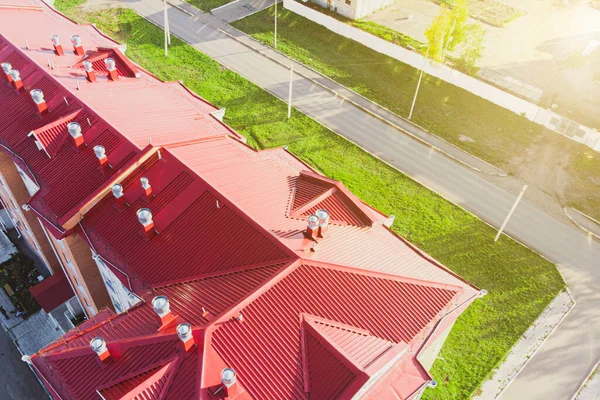 the roof of a building made of iron polymer sheets with ventilation diffusers and air ducts, photographed from a drone at a low altitude