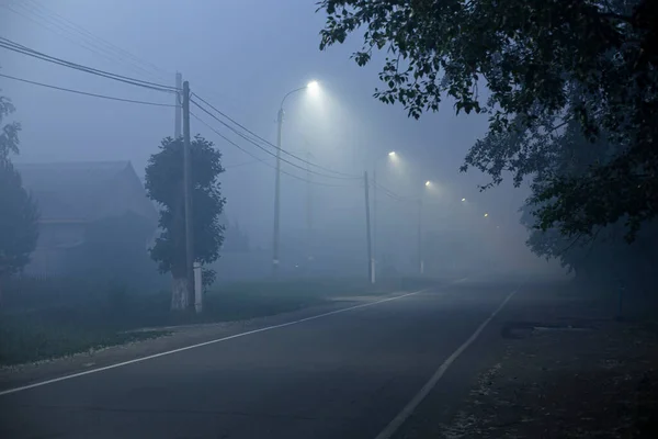 atmospheric photo in a smoky area of the city with private houses in the evening under the spotlights