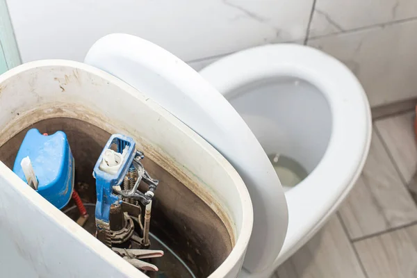 open toilet cistern when flush system breaks down, dirty poorly paid plumbing job
