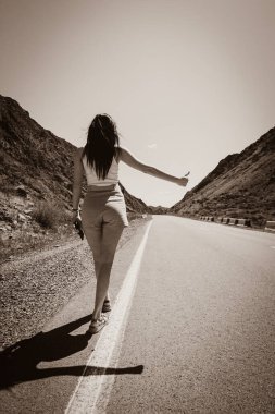 Dağlarda çölde taksiye binmeye çalışan bir kız.