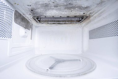 Temizlikten önce ve sonra temiz ve kirli mikrodalga fırın, yakın plan. Yıkandıktan ve temizlendikten sonra mutfak eşyaları..