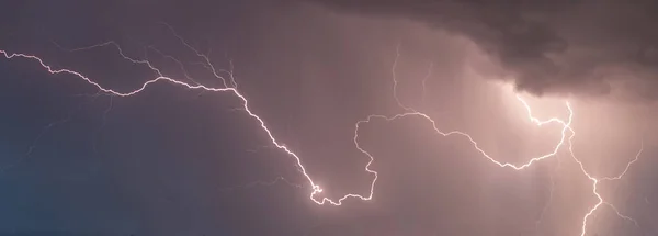 stock image beautiful lightning during a thunderstorm at night in a forest that caused a fire, against a dark sky with rain