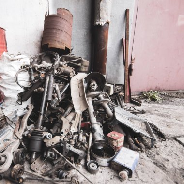 Hurda metal için yığılmış teknik servis istasyonunda çıkarılmış bir araba parçası yığını.