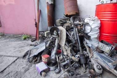 Hurda metal için yığılmış teknik servis istasyonunda çıkarılmış bir araba parçası yığını.
