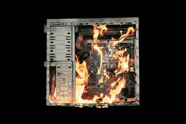 a burning system unit from a computer from a short circuit and a power surge on a black isolated background