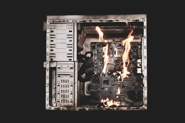 a burning system unit from a computer from a short circuit and a power surge on a black isolated background