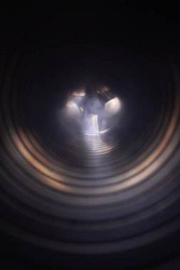 Bir alışveriş merkezinin havalandırma kanalında duman, egzoz vantilatörünün bulanık arka planında