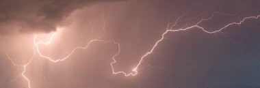 Gece gök gürültülü bir fırtınada, karanlık gökyüzüne karşı, bir yangına neden olan bir ormanda, yağmurlu bir fırtınada güzel bir yıldırım.