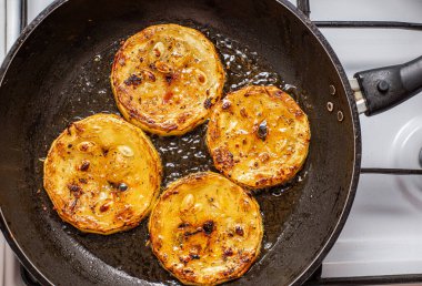 Fırınlanmış tavada zeytinyağında baharatlı kabak kızartma işlemi.