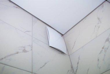 Duştaki vantilatör kapalıydı. Dekoratif bir kapağı, yayıcısı ve banyodaki perdesi vardı.