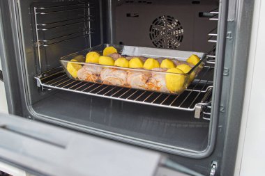 Tavuk butları ve patatesler fırında yakın plan ızgarada.