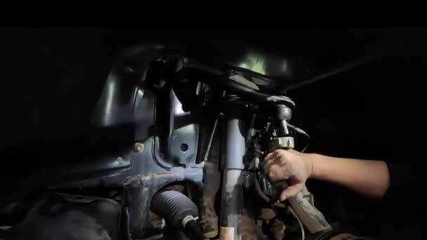 シャーシのガレージのクローズアップで車の修理 過酷で緊急な条件で照明が悪い — ストック動画